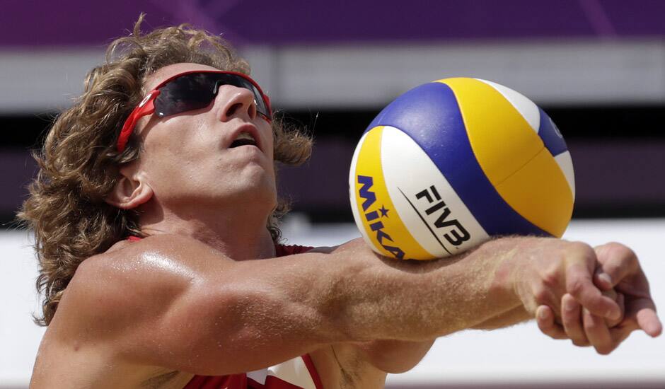 Aleksandrs Samoilovs of Latvia sets the ball during a beach volleyball match against the Republic of South Africa at the 2012 Summer Olympics in London.