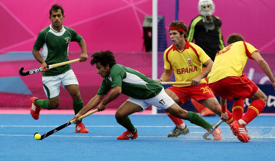 Pakistan's Waseem Ahmad, and Spain's David Alegre vie for the ball during their men's field hockey preliminary-round match at the 2012 Summer Olympics in London.