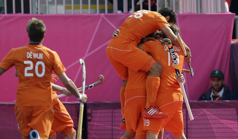 The Netherlands' Valentin Verga (26) jumps on top of his teammates, including Roderick Weusthof, shortly after scoring a goal in the men's hockey preliminary match against India at the 2012 Summer Olympics.