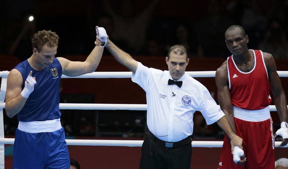 Germany's Enrico Kolling, left, reacts after defeating Cameroon's Christian Donfack Adjoufack in a men's light heavy 81-kg boxing match at the 2012 Summer Olympics.