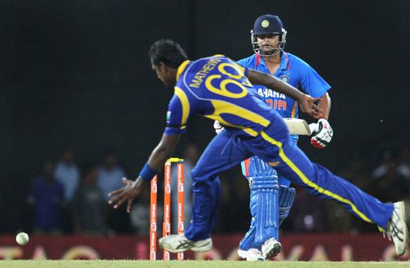 Sri Lanka's Angelo Mathews reaches to stop a ball as India's batsman Suresh Raina watches during the third one-day international cricket match between India and Sri Lanka in Colombo.