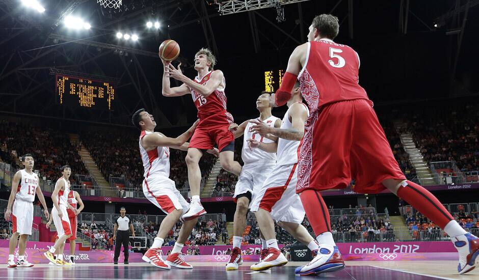 Russia's Andrei Kirilenko (15) shoots between China's Wang Zhizhi, left, and China's Yi Jianlian, right, during the first half of a preliminary en's basketball game at the 2012 Summer Olympics in London.