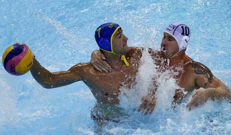 Peter Biros, right, of Hungary defends against Mladan Janovic of Montenegro during a preliminary men's water polo match at the 2012 Summer Olympics.