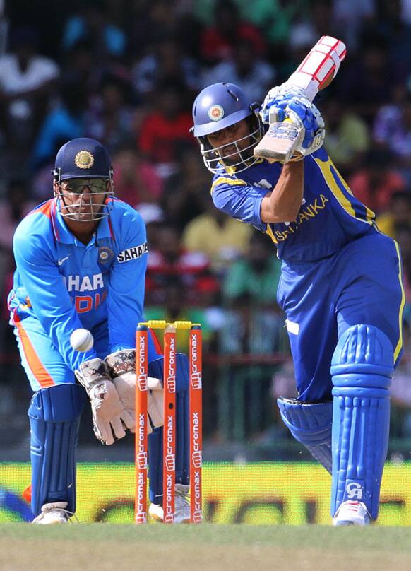 Tillakaratne Dilshan, right bats as India's captain Mahendra Singh Dhoni, left watches during the fourth one-day international cricket match between India and Sri Lanka in Colombo.