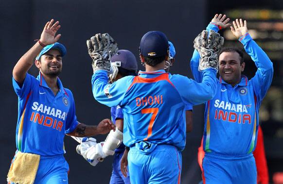 Virender Sehwag, right celebrates the dismissal of Sri Lanka's captain Mahela Jayawardene, unseen, with Virat Kohli, left and captain Mahendra Singh Dhoni, second right during the fourth one-day international cricket match between India and Sri Lanka in Colombo.