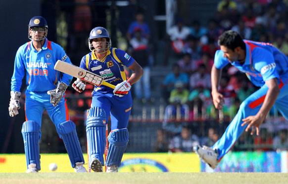 Manoj Tiwary, reaches to hold the ball as Dinesh Chandimal, and India's captain MS Dhoni, watch during the fourth one-day international cricket match between India and Sri Lanka in Colombo.