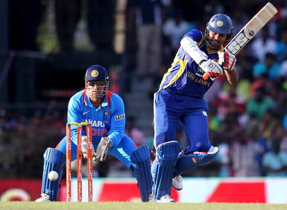 Sri Lanka's batsman Lahiru Thirimanne ,right, bats as captain Mahendra Singh Dhoni watches during the fourth one-day international cricket match between India and Sri Lanka in Colombo.