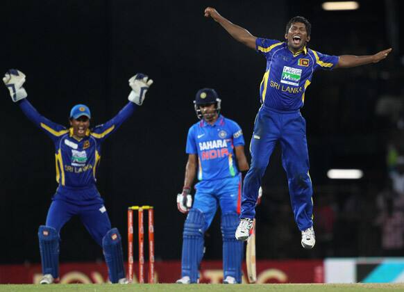 Jeevan Mendis and wicket keeper Dinesh Chandimal, appeal successfully for a LBW decision against India's batsman Manoj Tiwary, center, during the fourth one-day international cricket match between India and Sri Lanka in Colombo.