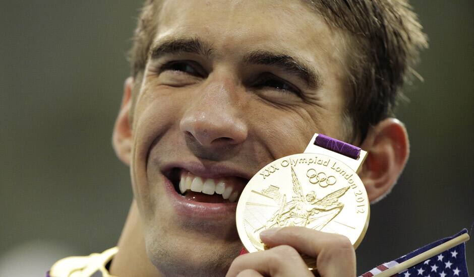 United States' Michael Phelps poses with his gold medal for the men's 4x200-meter freestyle relay swimming final at the Aquatics Centre in the Olympic Park during the 2012 Summer Olympics in London.