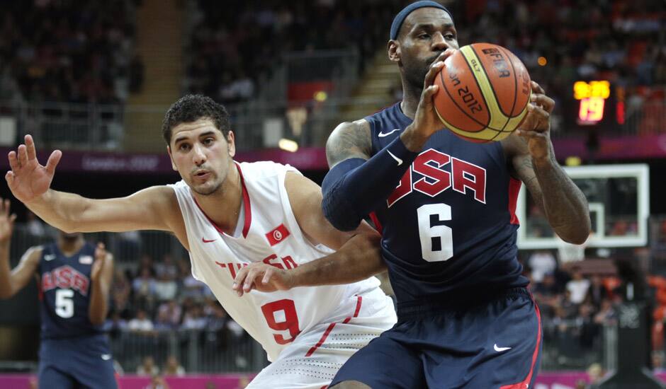 USA's Lebron James (6) looks to pass as he is pressured by Tunisia's Mohamed Hadidane during a men's basketball game at the 2012 Summer Olympics in London.