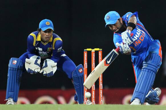 Virat Kohli, right bats as Sri Lanka's wickets keeper Dinesh Chandimal, left watches during the fourth one-day international cricket match between India and Sri Lanka in Colombo.