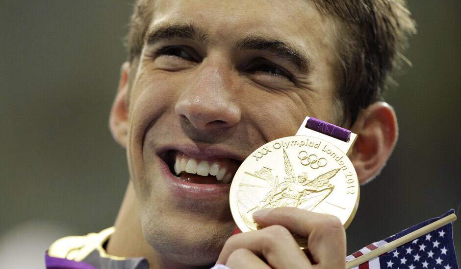 United States' Michael Phelps poses with his gold medal for the men's 4x200-meter freestyle relay swimming final at the Aquatics Centre in the Olympic Park during the 2012 Summer Olympics in London.