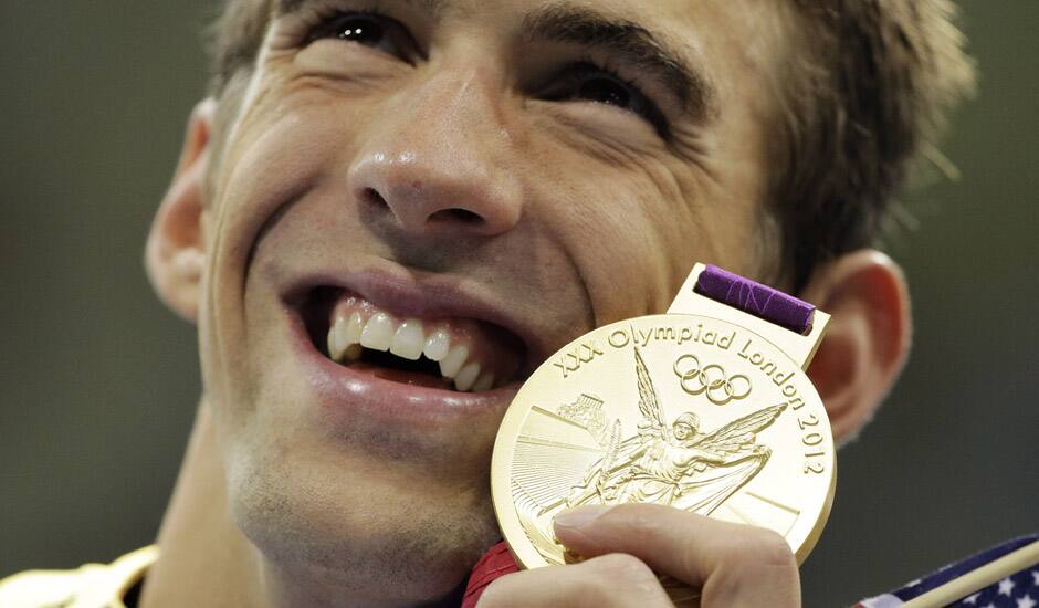 United States' Michael Phelps poses with his gold medal for the men's 4x200-meter freestyle relay swimming final at the Aquatics Centre in the Olympic Park during the 2012 Summer Olympics in London.