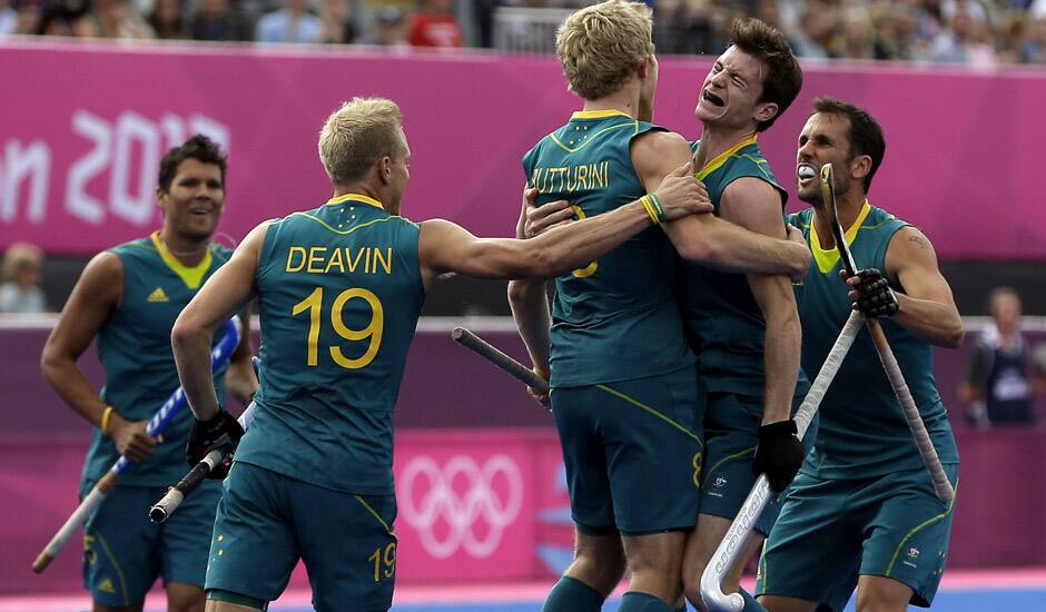 Australia's Matthew Butturini (8) celebrates his goal with teammates during their men's hockey preliminary match against Spain at the 2012 Summer Olympics in London. Australia won 5-0. 