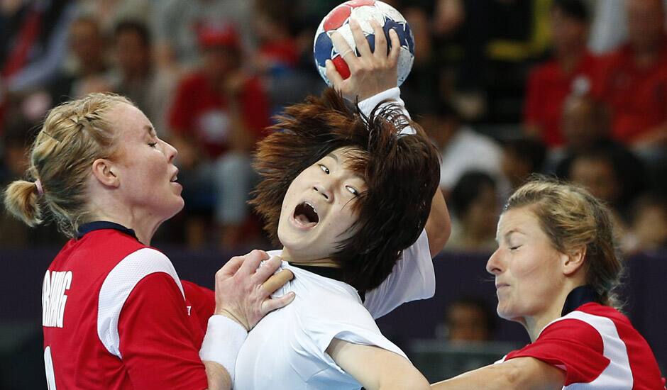 South Korea's Jo Hyo-bi, center is tackled by Norway's Karoline Dyhre Breivang, left, and Lynn-Kristin Koren, right, during their women's handball preliminary match at the 2012 Summer Olympics in London.