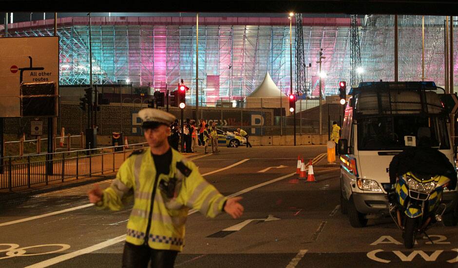 A police officer stands at the scene where the driver of an official Olympic bus carrying journalists has been arrested after a bicyclist was hit and killed, near the Olympic Park in Stratford, London.