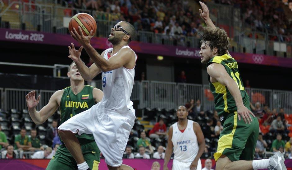 France's Tony Parker drives to the basket past Lithuania's Simas Jasaitis during a men's basketball game at the 2012 Summer Olympics.