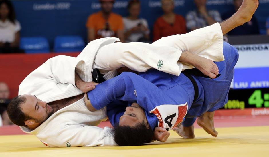 Jevgenijs Borodavko of Latvia competes against Anthony Liu of American Samoa (in blue) during the men's 100-kg judo competition at the 2012 Summer Olympics.