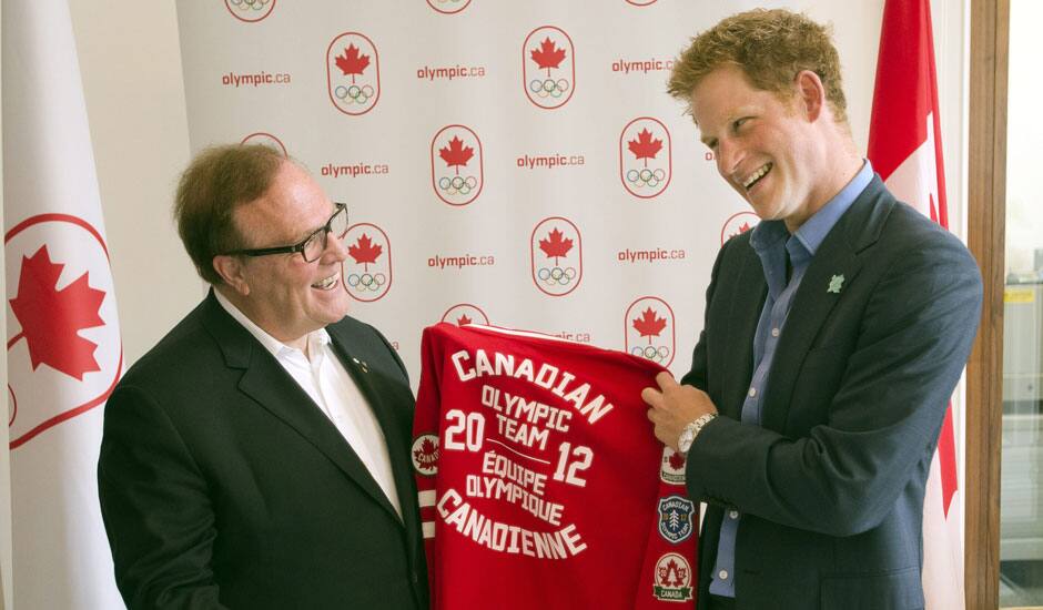 Prince Harry receives a Canadian team jacket from Canadian Olympic Committee President Marcel Aubut during his visit to Canada House at the 2012 Summer Olympics.