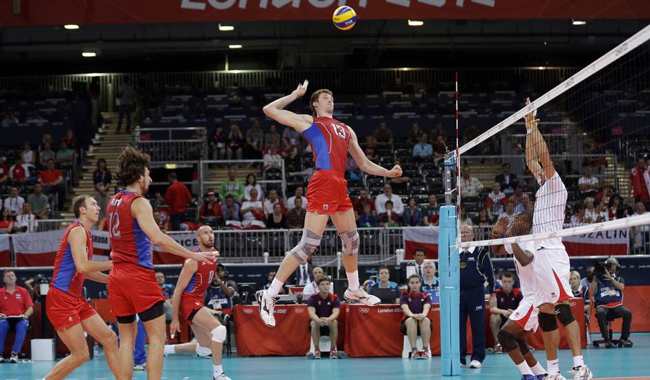 Russia's Dmitriy Muserskiy (13) goes up for a spike against the Tunisia defense during a men's volleyball preliminary match at the 2012 Summer Olympics.