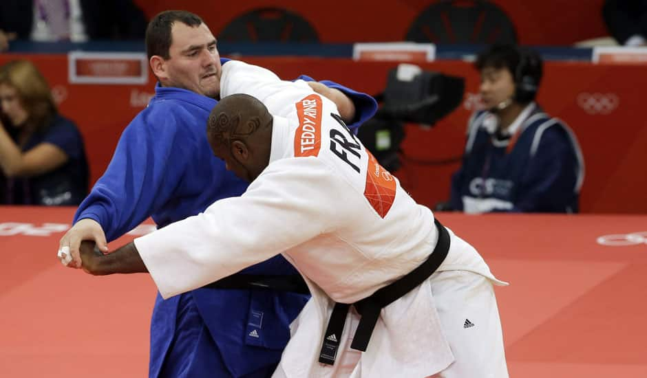 France's Teddy Riner and Poland's Janusz Wojnarowicz compete during the elimination round of 32 at men's 100-kg judo at the 2012 Summer Olympics.