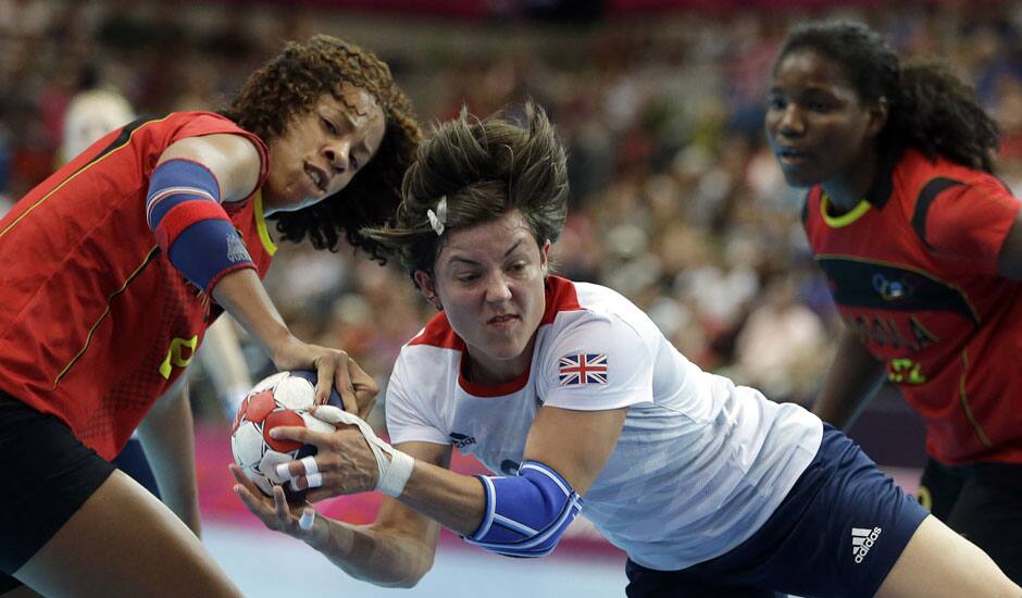 Marie Gerbron of Great Britain challenges with Nair Almeida, left, and Isabel Fernandes of Angola during their women's handball preliminary match at the 2012 Summer Olympics.