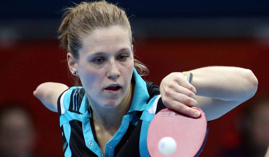 Poland's Nataila Partyka returns a shot to Singapore's Yuegu Wang and Jiawei Li during the women's team table tennis competition at the 2012 Summer Olympics in London.