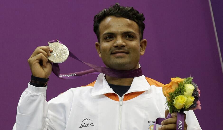 Vijay Kumar reacts displays his silver medal, during the victory ceremony for the men's 25-meter rapid fire pistol event at the 2012 Summer Olympics in London.