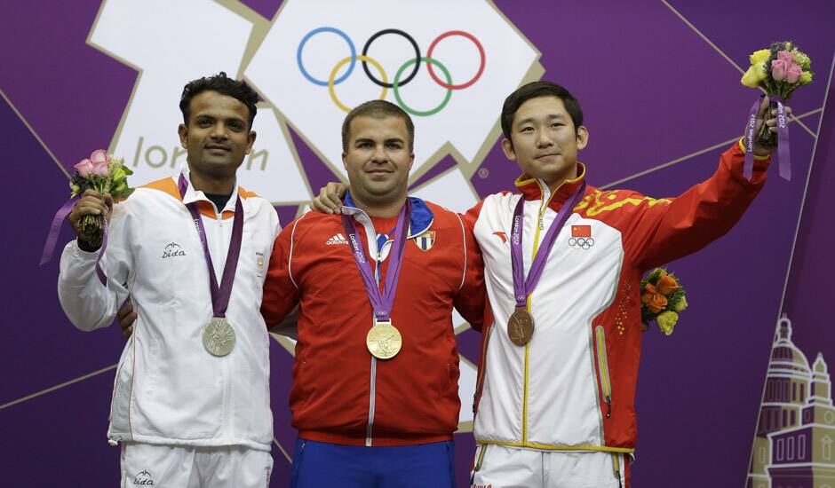 Gold medalist, Cuba's Leuris Pupo, center poses for a picture with silver medalist, India's Vijay Kumar, and bronze medalist, China's Zhang Jian during the victory ceremony for the men's 25-meter rapid fire pistol event at the 2012 Summer Olympics, in London. 