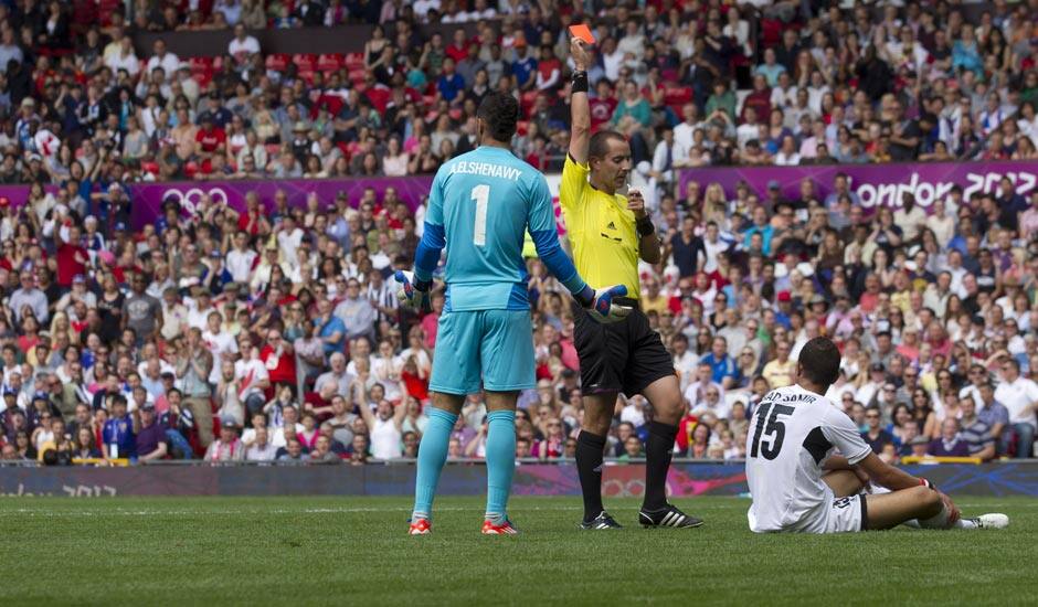 Egypt's Saadeldin Saad, bottom right, is sent off by official Mark Geiger after a foul on Japan's Manabu Saito, left, as Egypt's goalkeeper Ahmed Elshenawi stands by during their quarter-final men's soccer match at the London 2012 Summer Olympics.