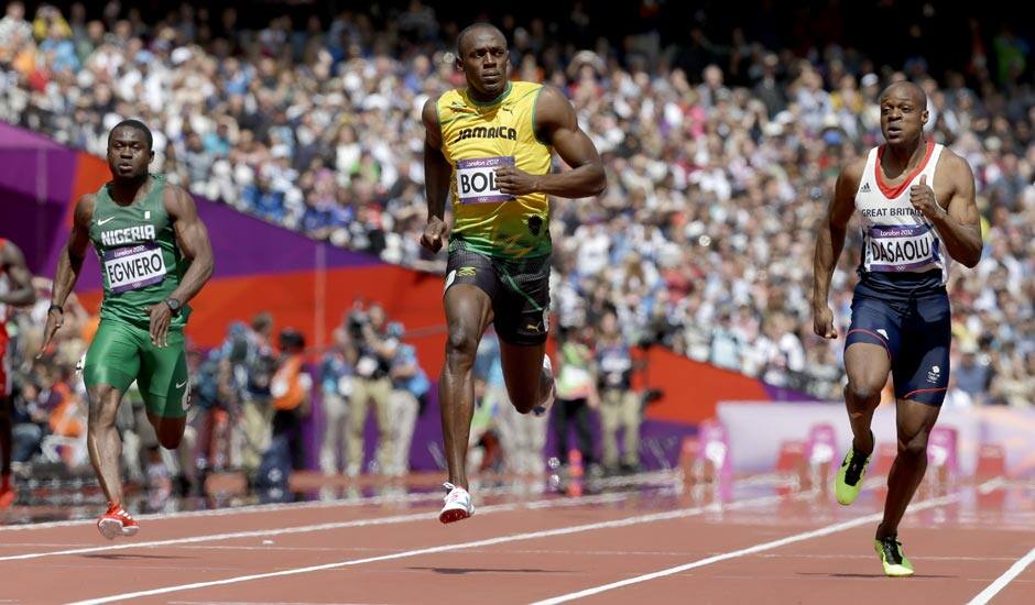 Nigeria's Ogho-Oghene Egwero, left, Jamaica's Usain Bolt, center, and Britain's James Dasaolu compete in a men's 100-meter heat during the athletics in the Olympic Stadium at the 2012 Summer Olympics.