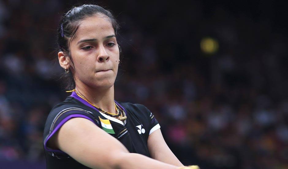 Saina Nehwal serves against Belgium's Lianne Tan, unseen, at a woman's singles badminton match of the 2012 Summer Olympics.