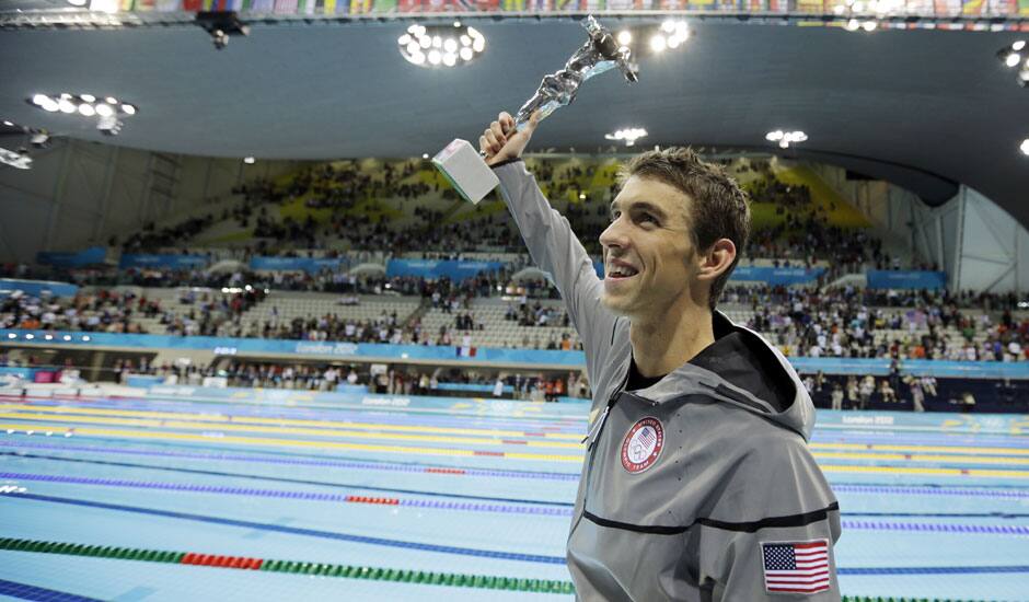 United States' swimmer Michael Phelps holds up a silver trophy after being honored as the most decorated Olympian at the Aquatics Centre in the Olympic Park during the 2012 Summer Olympics in London