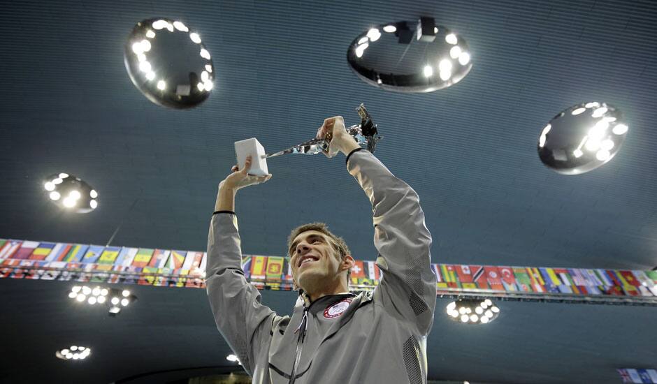 United States' swimmer Michael Phelps holds up a silver trophy after being honored as the most decorated Olympian at the Aquatics Centre in the Olympic Park during the 2012 Summer Olympics in London