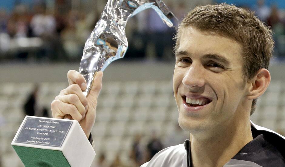 United States' swimmer Michael Phelps holds up a silver trophy after being honored as the most decorated Olympian at the Aquatics Centre in the Olympic Park during the 2012 Summer Olympics in London