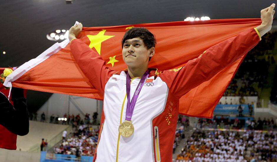 China's Sun Yang holds his national flag as he celebrates his gold medal win in the men's 1500-meter freestyle swimming final at the Aquatics Centre in the Olympic Park during the 2012 Summer Olympics.