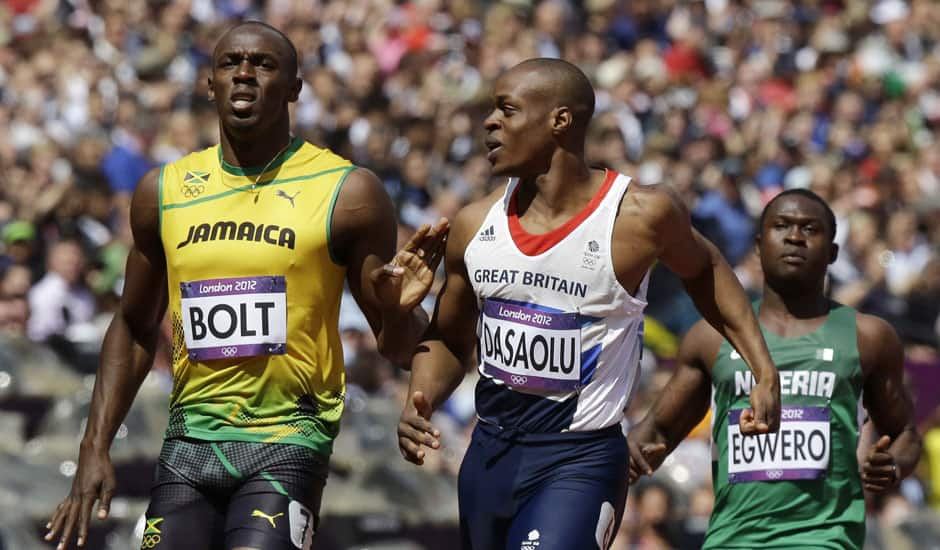 Jamaica's Usain Bolt, left, reacts after winning ahead of Nigeria's Ogho-Oghene Egwero, right, and Britain's James Dasaolu in a men's 100-meter heat during the athletics in the Olympic Stadium at the 2012 Summer Olympics.