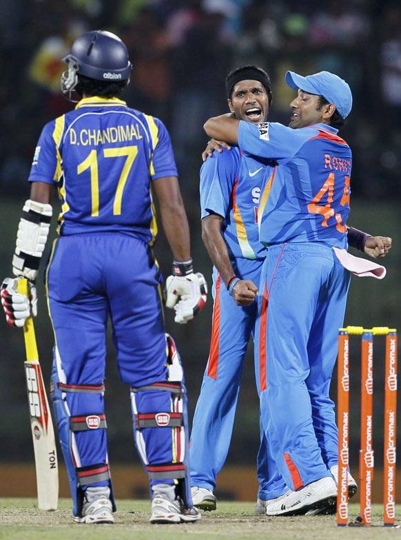 Ashok Dinda, center, celebrates the dismissal of Sri Lanka's batsman Dinesh Chandimal, left, with Rohit Sharma, right, during the fifth one day international cricket match between India and Sri Lanka in Pallekele.