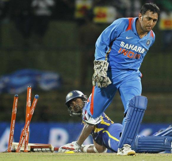 Mahendra Singh Dhoni, right celebrates after removing stumps to get a run out against Sri Lanka's batsman Lahiru Thirimanne, left during the fifth one day international cricket match between India and Sri Lanka in Pallekele, Sri Lanka.