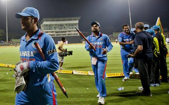 Mahendra Singh Dhoni, right, and Virat Kohli, second right lead the team back to pavilion after India beat Sri Lanka in the final one day international to win the five- match ODI series 4-1 in Pallekele.