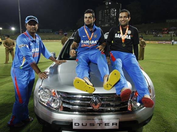 Virat Kohli pose with the SUV that he won as the man-of the series with teammates Irfan Pathan, right and Pragyan Ojha, left after India beat Sri Lanka in the final one day international to win the five- match ODI series 4-1 in Pallekele.