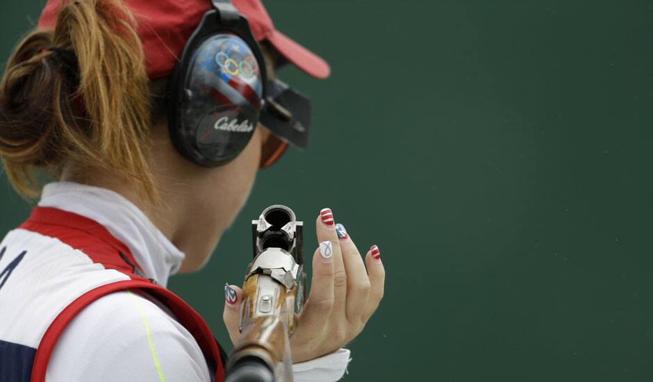 United States of America's Corey Cogdell holds her gun, with fingernails painted in designs in the colors of the U.S. flag, as she waits her turn to shoot, during qualifiers for the women's trap event, at the 2012 Summer Olympics.