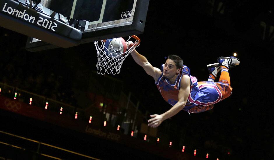 An ariel performer flies and slams a dunk during halftime of a women's basketball game between Russia and France at the 2012 Summer Olympics.