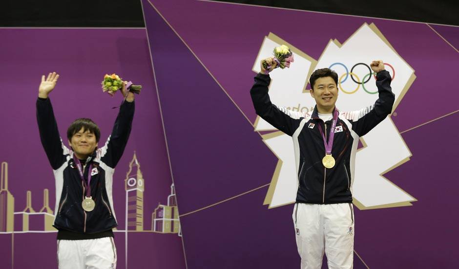 Gold medal winner, South Korea's Jin Jong-oh, right, celebrates with countryman Choi Young-rae, who took silver, during the victory ceremony for the men's 50-meter pistol, at the 2012 Summer Olympics.