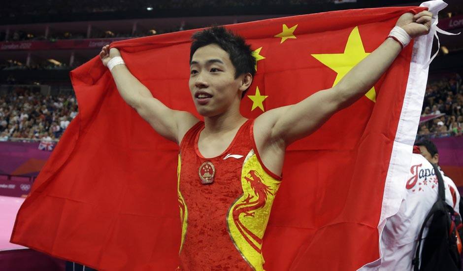 Chinese gymnast Zou Kai holds his national flag after winning the gold for the men's floor exercise finals at the 2012 Summer Olympics.