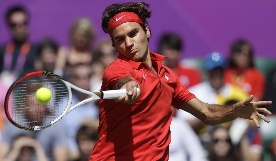 Switzerland's Roger Federer returns a shot to Britain's Andy Murray during the men's singles gold medal match at the All England Lawn Tennis Club at Wimbledon, in London, at the 2012 Summer Olympics.