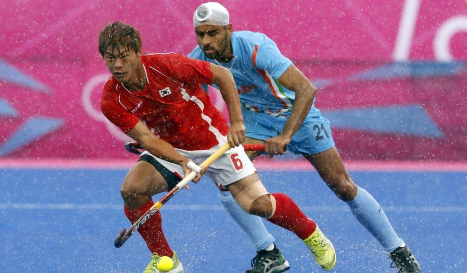 Sardar Singh, right and South Korea's Lee Nam-yong vie for the ball their men's hockey preliminary round match against Pakistan at the 2012 Summer Olympics.