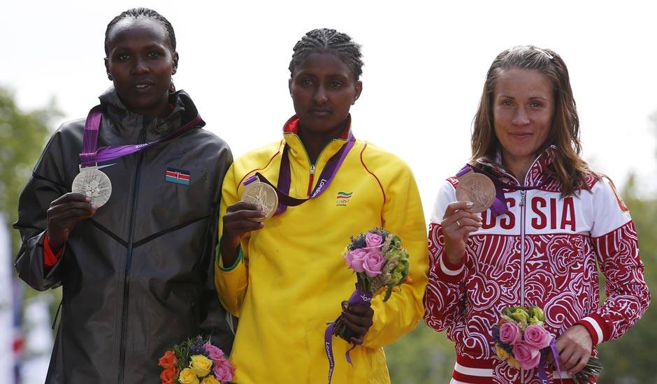 Ethiopia's Tiki Gelana is flanked by Kenya's silver medal winner Priscah Jeptoo, left, and Russia's bronze medalist Tatyana Petrova Arkhipova during the ceremony for the women's marathon at the 2012 Summer Olympics.