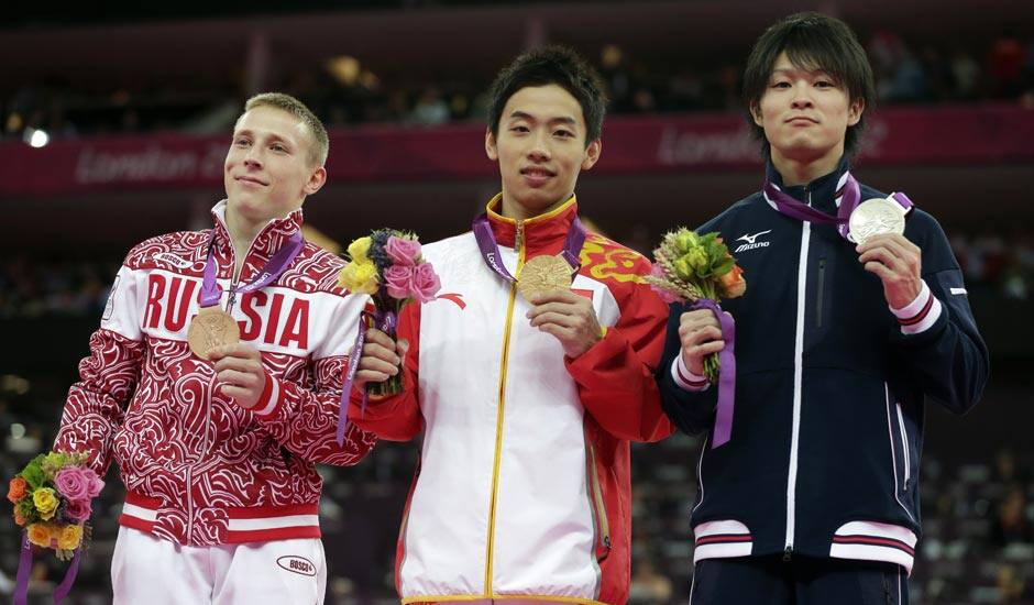 Russian bronze medallist Denis Ablyazin, left, Chinese gold medallist Zou Kai, center, and Japanese silver medallist Kohei Uchimura display their medals during the podium ceremony for the men's floor exercise finals at the 2012 Summer Olympics.