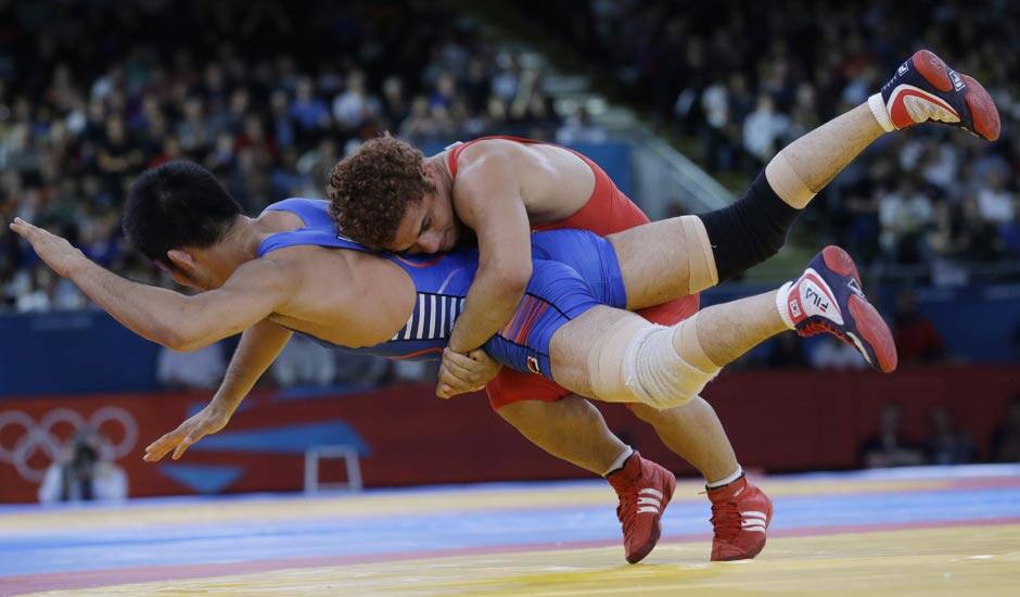 Cuba's Gustavo Balart, right, takes South Korea's Choi Gyu-jin to the mat 55-kg Greco-Roman wrestling competition at the 2012 Summer Olympics.